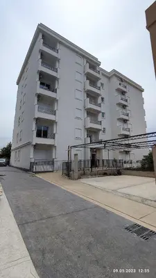 a large white building with balconies on a street at Apartments LORA Susanj in Bar