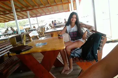 a woman is sitting at a table at a table at Vila Elkom, Apartment 5 in Ulcinj
