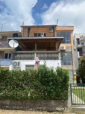 a building with an umbrella sitting on the balcony at Apartmani Ema in Sutomore