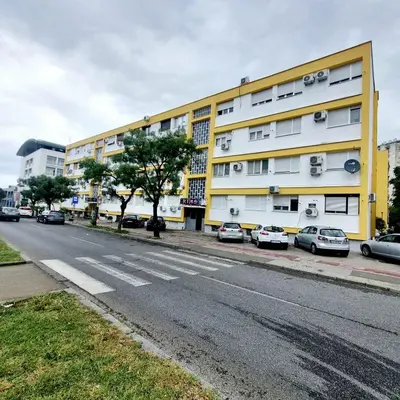 an empty street with cars parked in front of a building at Apartman Podgorica in Podgorica
