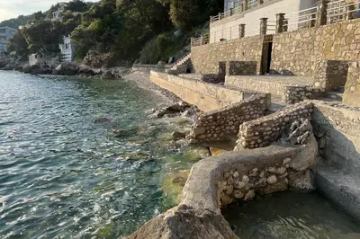 a group of steps next to a body of water at Sea Breeze Apartment in Kruče