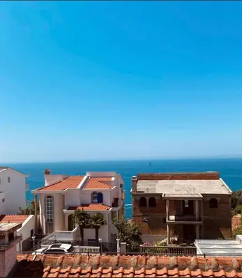 a view of a house with the ocean in the background at Glendza Apartman in Ulcinj