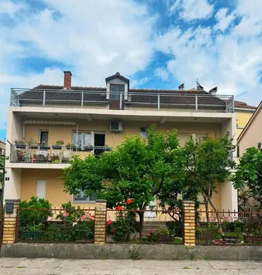 a large house with a fence in front of it at Prestige in Podgorica