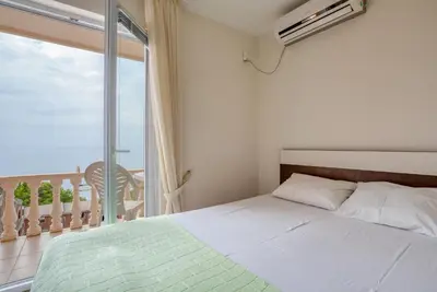 a bedroom with a bed and a large window at Snežna Kraljica in Sutomore