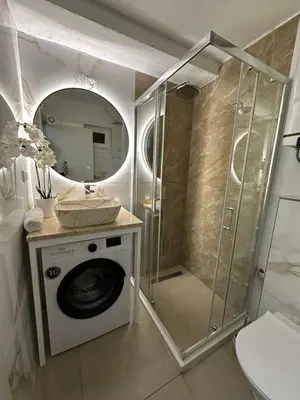 a bathroom with a shower and a washing machine at Budva apartman Centar in Budva