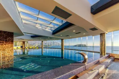 an indoor swimming pool with a view of the water at Two rooms in Tre canne hotel in Budva