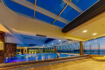 an indoor swimming pool in a building with blue ceilings at Luxury one bedroom apartment in beachfront apart Hotel in Budva