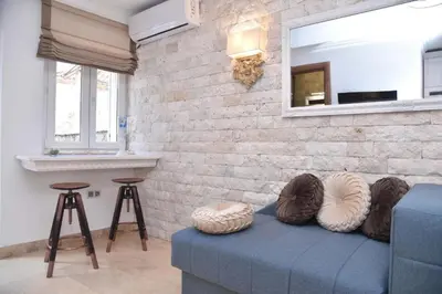 a living room with a blue couch and a brick wall at OLD TOWN Budva apart 3 with balcony in Budva