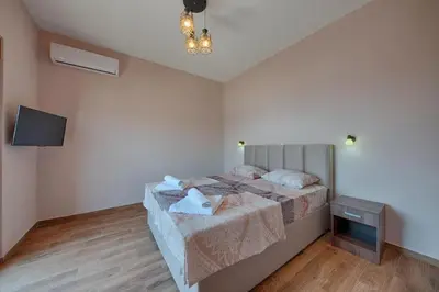 a bedroom with a bed and a flat screen tv at PETROVIĆ in Bar