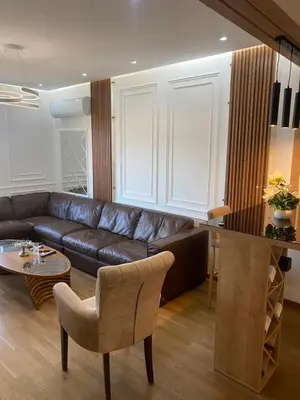 a living room with a leather couch and a table at Rent a apartment Podgorica in Podgorica