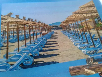 a painting of a beach with chairs and umbrellas at Apartmen Donji Stoj, yellow in Donji Štoj