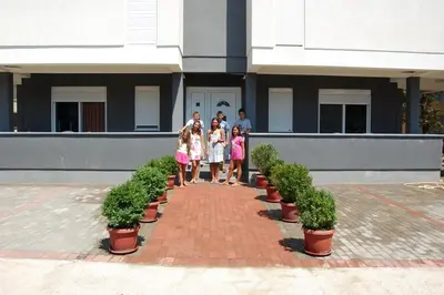 a group of people standing in front of a building at Apartmen Donji Stoj, yellow in Donji Štoj