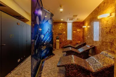 a bathroom with a tv and some benches in a room at Luxury apart with 3 bedrooms in hotel near the beach in Budva