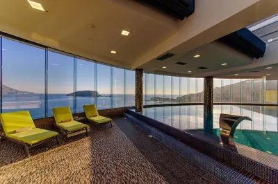 a room with two chairs and a swimming pool at Luxury 3 bedroom flat in Tre canne hotel next to the beach in Budva