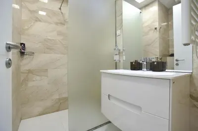 a white bathroom with a sink and a shower at Luxury apartment with 2 rooms in hotel Tre canne in Budva
