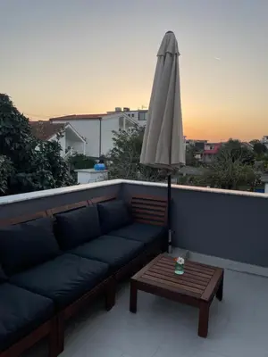 a couch and a table with an umbrella on a roof at Grapefruit Home Apartment Ulcinj Montenegro in Donji Štoj