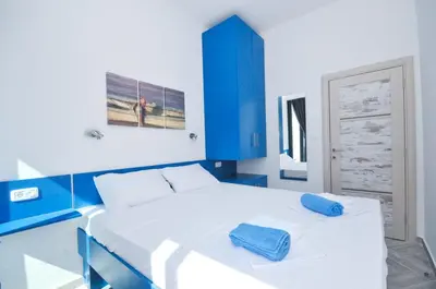 a blue and white bedroom with a large bed at Apartments Jadranski Biser in Čanj