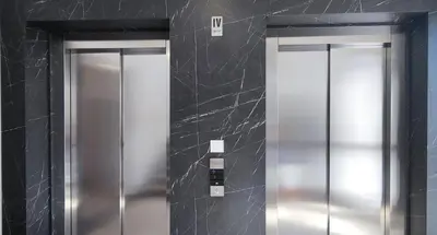 two elevators in a bathroom with black walls at Elegant Apartment with Urban Charm in Podgorica