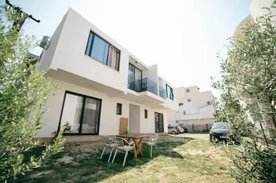 a house with a table and chairs in the yard at You GO in Velika Plaža