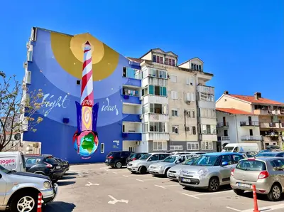 a parking lot with cars parked in front of a building at Homestay LGBT friendly - DOUBLE BED ROOM in Budva