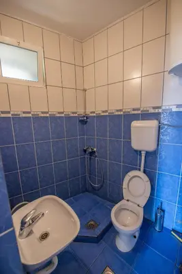 a blue tiled bathroom with a toilet and a sink at Lana Apartments Nr 1 in Ulcinj