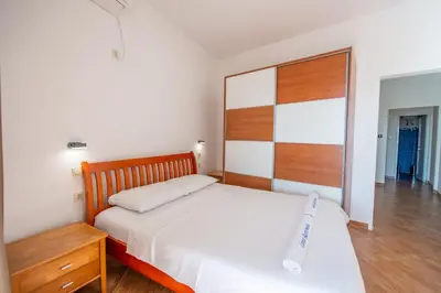 a bedroom with a large bed and a wooden headboard at Lana Apartments Nr 2 in Ulcinj