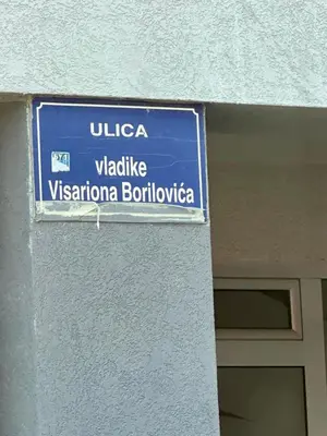 a blue street sign on the side of a building at Sunshine Master apartment in Podgorica