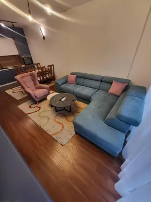 a living room with a blue couch and a table at Master apartment Podgorica in Podgorica