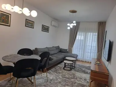 a living room with a couch and a table and chairs at Apartman Vlado Podgorica 2 in Podgorica