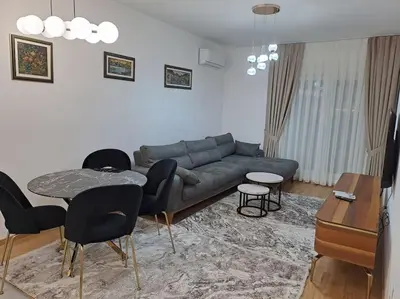 a living room with a couch and a table and chairs at Apartman Vlado Podgorica 2 in Podgorica