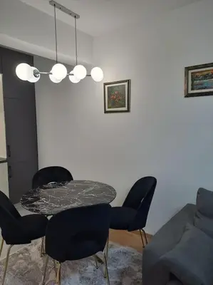 a dining room with a table and chairs and a couch at Apartman Vlado Podgorica 2 in Podgorica