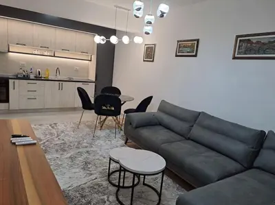 a living room with a couch and a table and chairs at Apartman Vlado Podgorica 2 in Podgorica