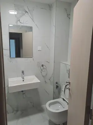 a white bathroom with a sink and a toilet at Apartman Vlado Podgorica in Podgorica