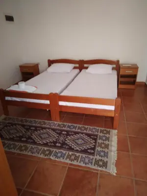 a bedroom with a bed and a rug at Mali apartman in Podličak