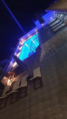 a swimming pool with a group of chairs next to it at Meli Apartman in Krimovice