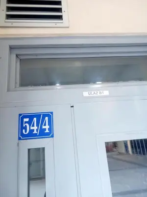 a door to a building with a sign on it at City center apartment in Podgorica