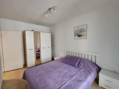 a bedroom with a purple bed and white walls at Vinogradi in Budva