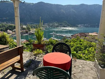 a table and chairs on a patio with a view of the water at Old Town Gem - Rooftop Terrace with Bay View in Kotor