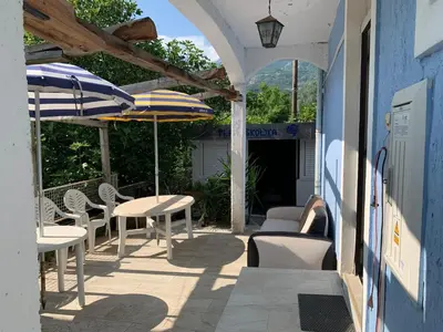 an outdoor patio with tables and chairs and umbrellas at Galicia Hills in Becici