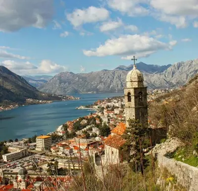 a view of a town with a church and a lake at lifekotor in Kotor