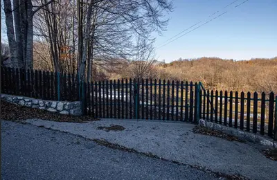 a black fence with a gate in front of it at Montenegro Rustic House I in Bjeloši