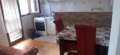 a kitchen with a table and a stove at Porodična kuća in Podgorica