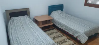 two beds sitting next to each other in a room at Porodična kuća in Podgorica