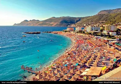 a beach with umbrellas and people in the water at Studio Dobra Voda 4 in Dobra Voda
