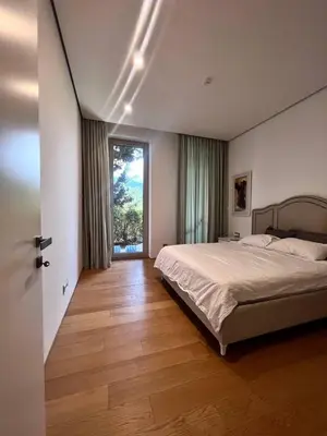 a bedroom with a bed and a large window at Duklejski pogled in Budva
