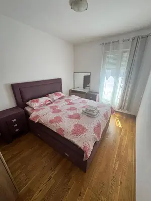 a bedroom with a bed and a desk and a window at Nema 2 in Kravlja
