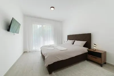 a bedroom with a large bed and a television at MM Apartments Brown in Budva