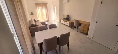 a living room with a white table and chairs at Apartmani Banović 3 - Ulcinj, Velika plaža in Ulcinj