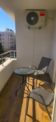 a table and chairs on a balcony with a fan at Apartmani Banović 2 - Ulcinj, Velika plaža in Ulcinj