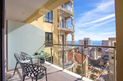 a balcony with a table and a view of the city at The Royal Summer & Spa in Becici